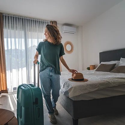 Cliente arrivant dans sa chambre d’hôtel avec sa valise, lors de l’enregistrement.